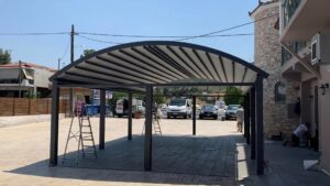 Καμπυλωτό στέγαστρο σε αυλή κατοικίας στη Λιβαδειά, ιδανικό για προστασία από τον ήλιο και τις καιρικές συνθήκες.